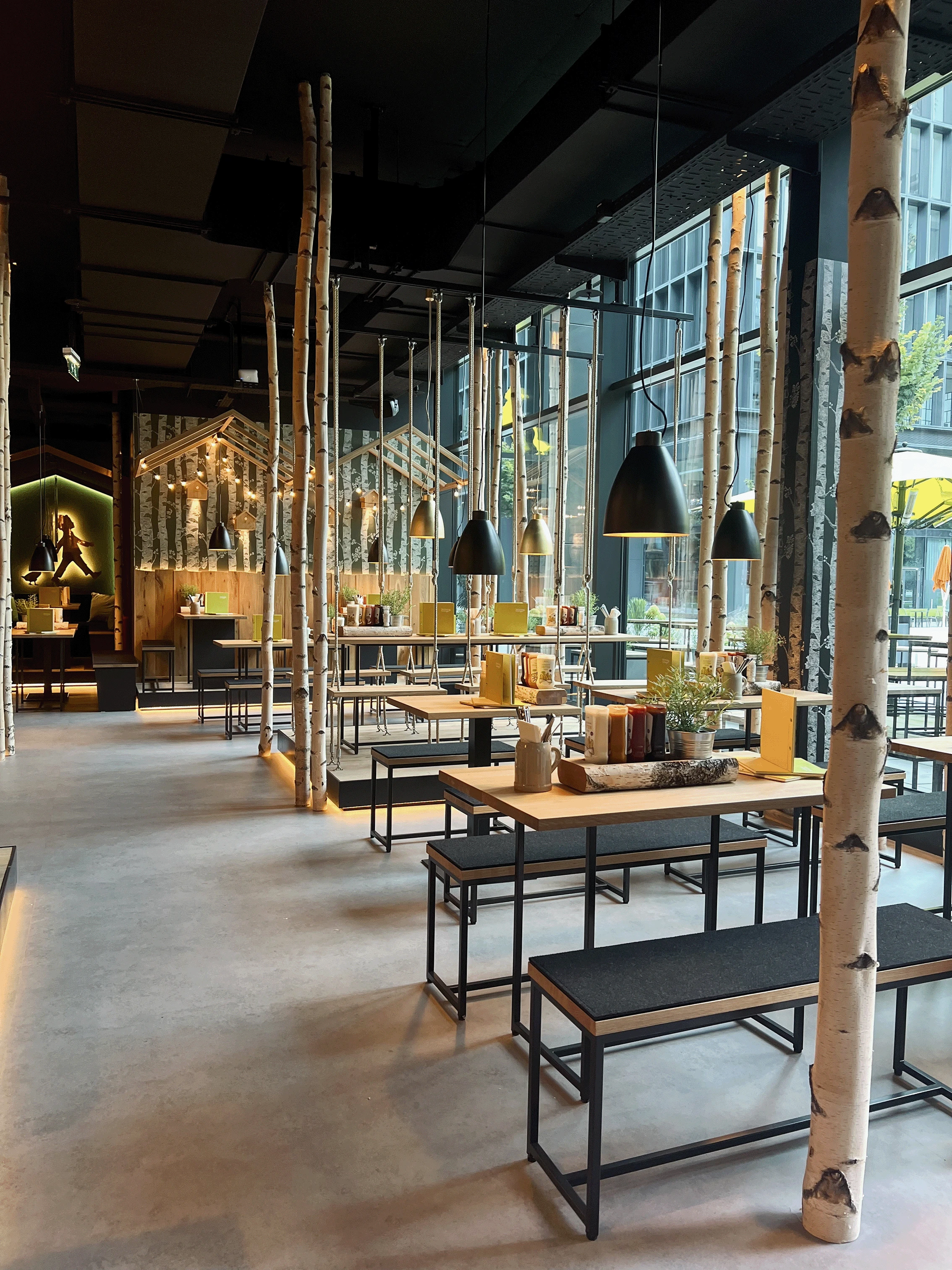 Restaurant mit Birkenstämmen und Holztischen